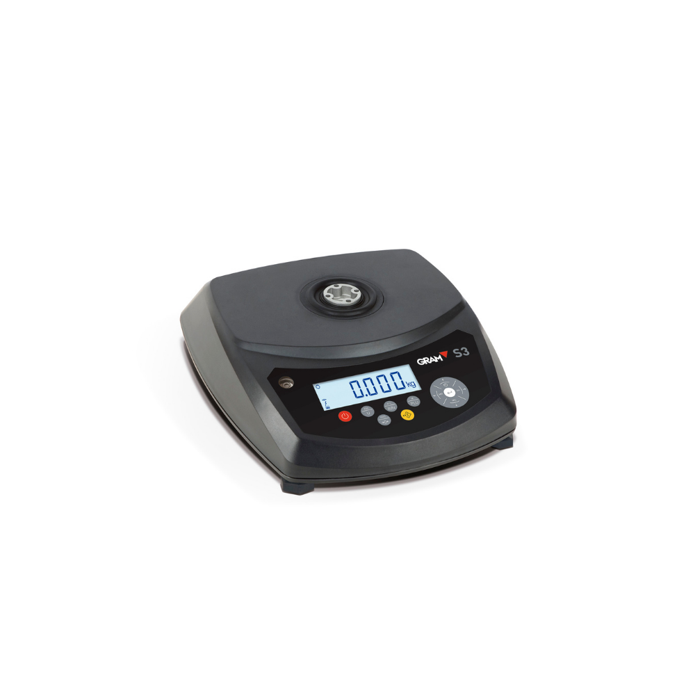 Balança GRAM S3 da Fábrica das Etiquetas, mostrada em uma mesa com visor digital e estrutura de plástico preto.